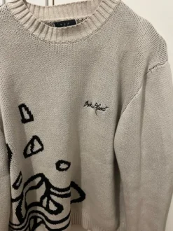 Beige stickad tröja med grafiskt tryck – stilren & unik